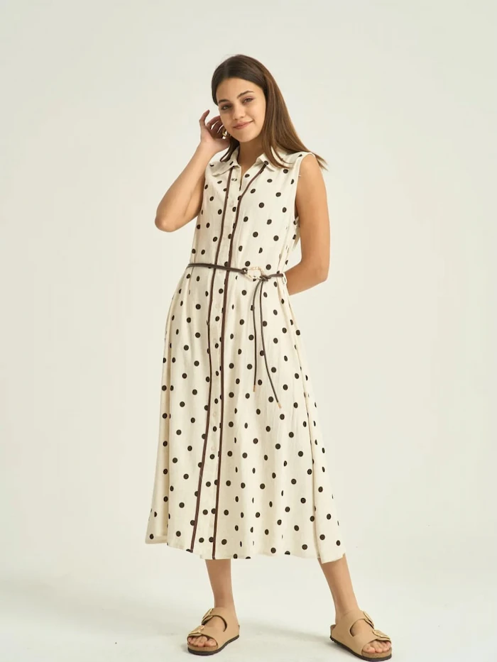 Cream sleeveless shirt dress with small brown polka dots and a thin rope belt